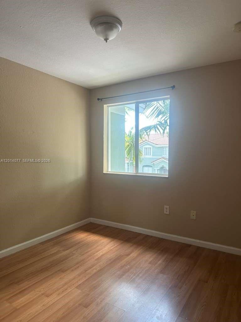 2913 Southeast 15th Road, Unit 64 Homestead, FL 33035 - Photo 12 of 14 a view of an empty room with wooden floor and a window