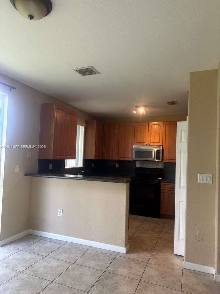 2913 Southeast 15th Road, Unit 64 Homestead, FL 33035 - Photo 2 of 14 a kitchen with a refrigerator and a sink