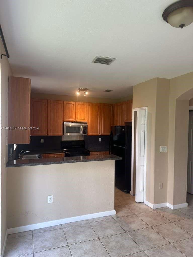 2913 Southeast 15th Road, Unit 64 Homestead, FL 33035 - Photo 3 of 14 a kitchen with a sink a refrigerator and a cabinets