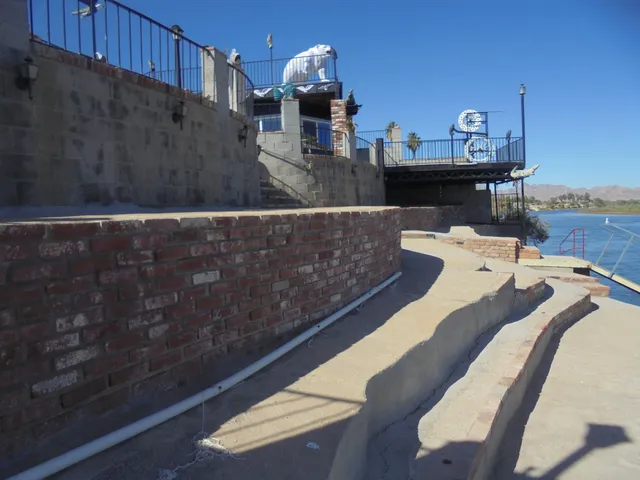 a view of dining room with kitchen island stainless steel appliances kitchen island granite countertop a table and chairs in it