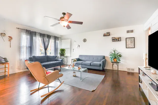 a living room with furniture a flat screen tv and a window