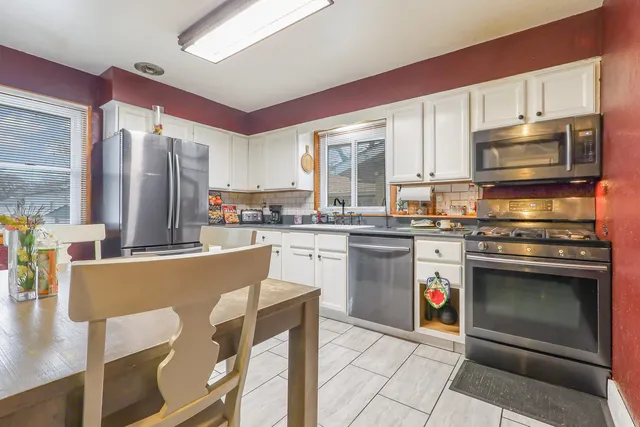 a kitchen with stainless steel appliances granite countertop a stove top oven a sink dishwasher and a refrigerator
