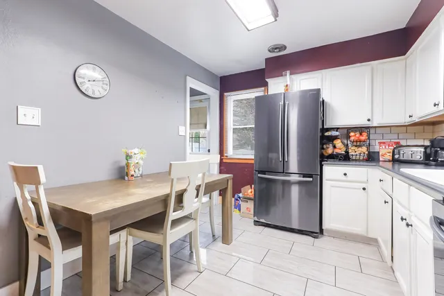 a kitchen with stainless steel appliances granite countertop a refrigerator a stove a sink dishwasher and white cabinets with wooden floors