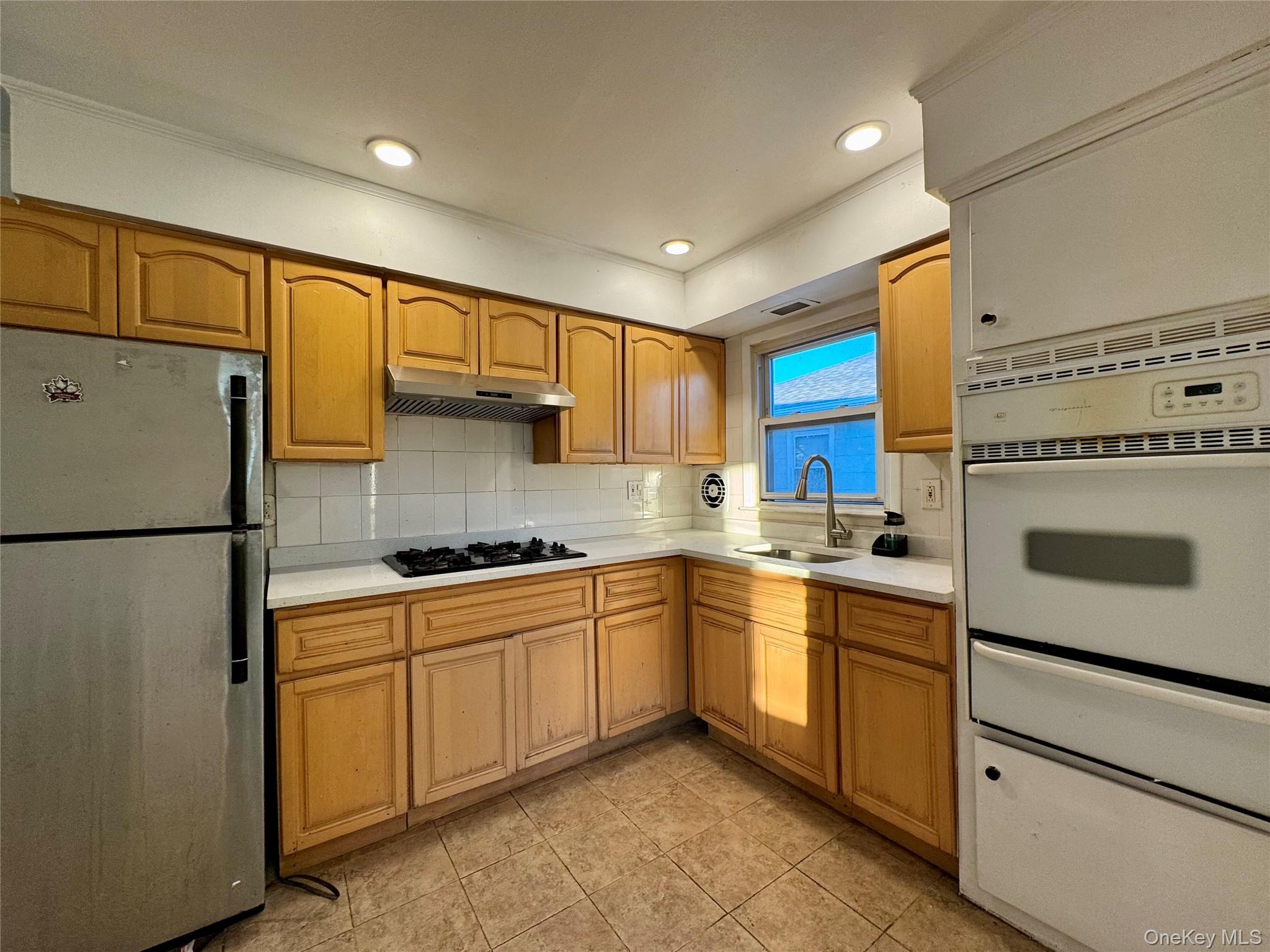 58 Cohill Road, Unit 2 Valley Stream, NY 11580 - Photo 12 of 23 a kitchen with a sink a refrigerator and cabinets