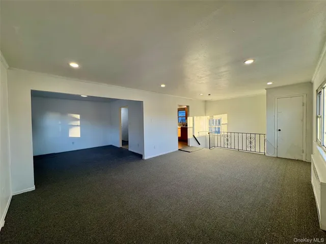 an empty room with windows and fireplace