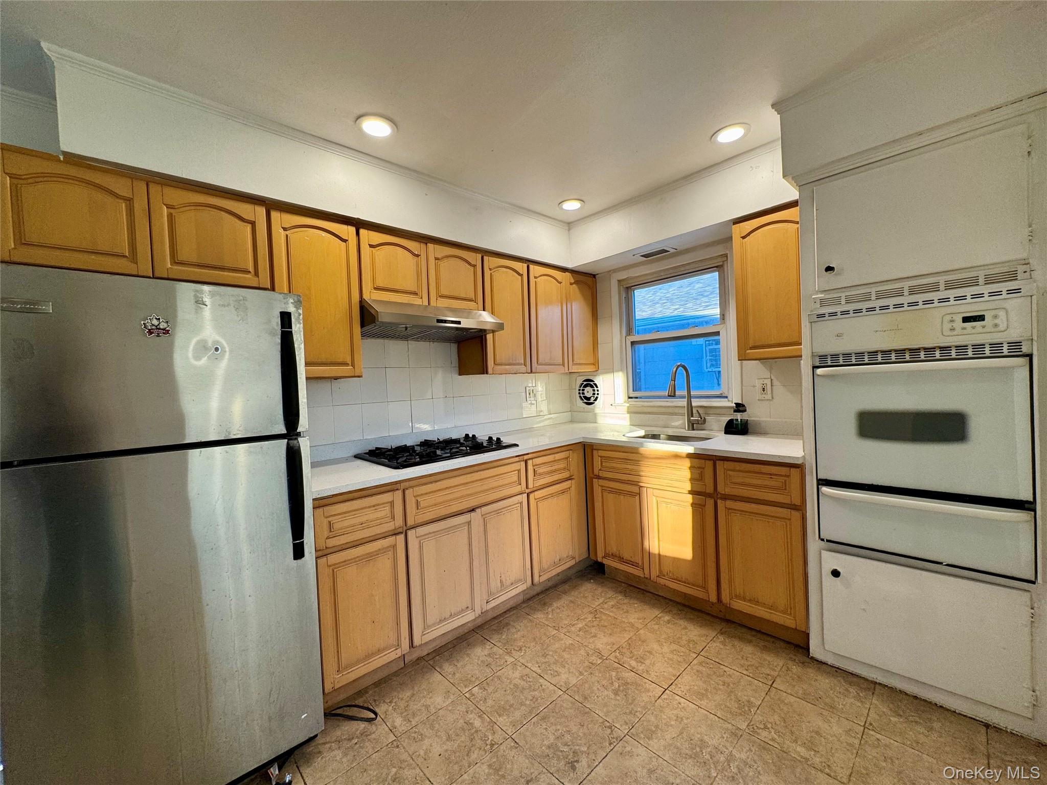 58 Cohill Road, Unit 2 Valley Stream, NY 11580 - Photo 9 of 23 a kitchen with stainless steel appliances granite countertop a refrigerator sink stove and cabinets