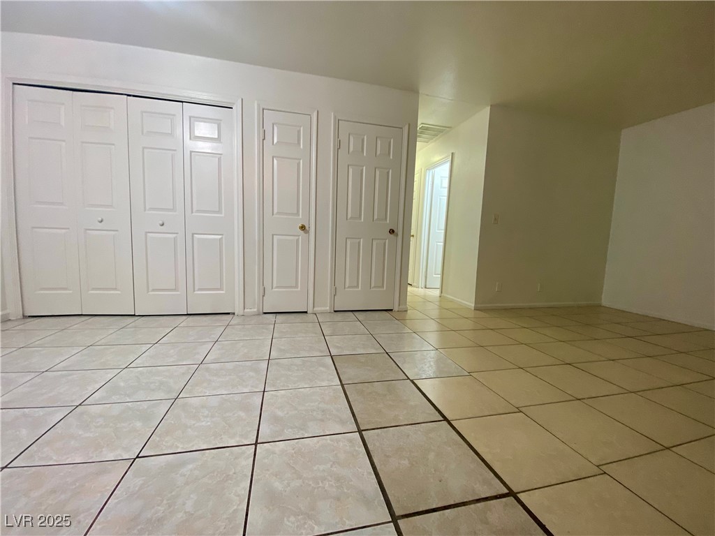 5284 Hagemann Lane, Unit D Las Vegas, NV 89110 - Photo 13 of 30 Unfurnished bedroom with light tile patterned floors and a closet