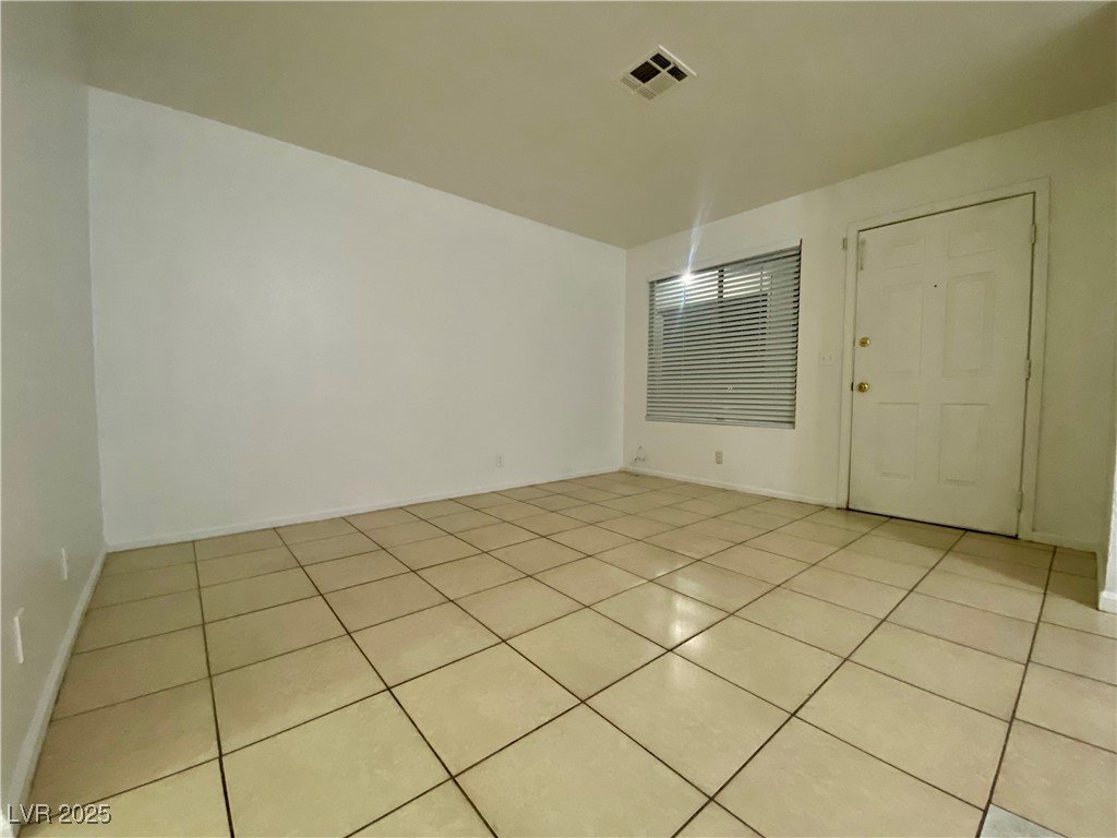 5284 Hagemann Lane, Unit D Las Vegas, NV 89110 - Photo 15 of 30 Empty room with light tile patterned floors and baseboards
