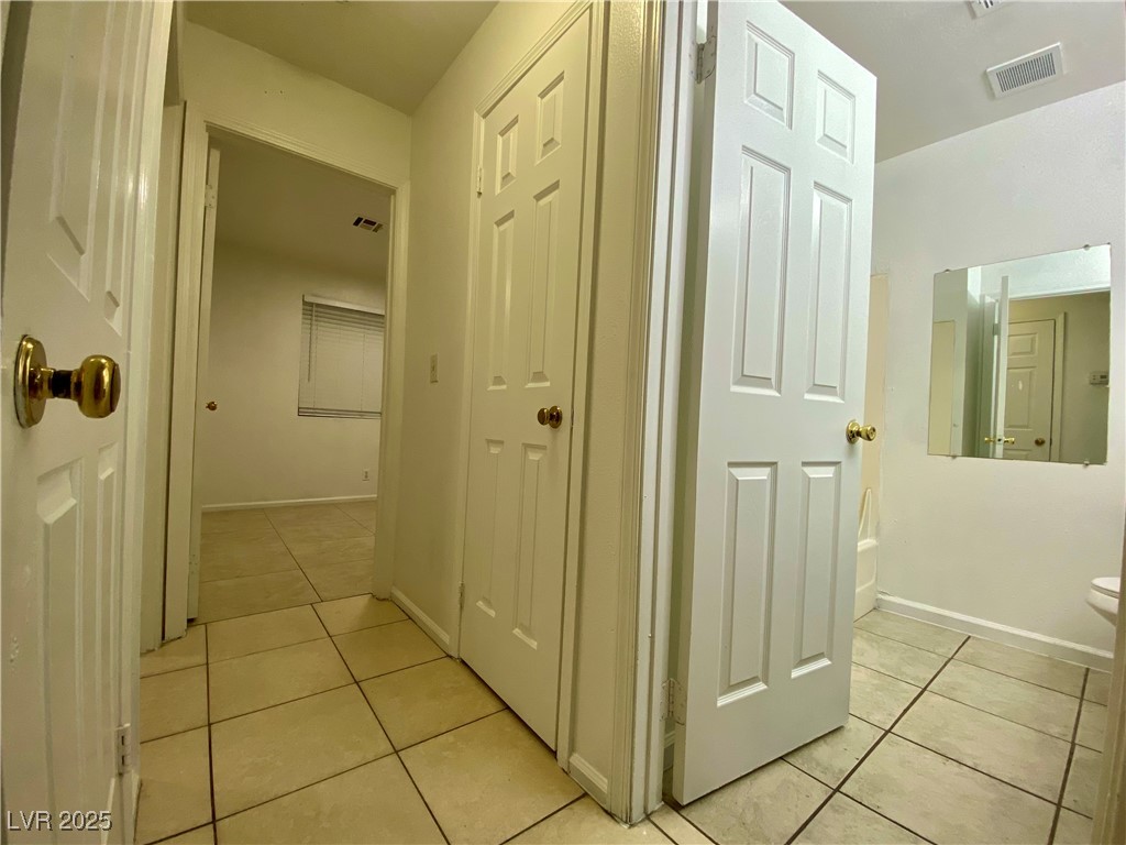 5284 Hagemann Lane, Unit D Las Vegas, NV 89110 - Photo 17 of 30 Corridor featuring light tile patterned flooring and baseboards