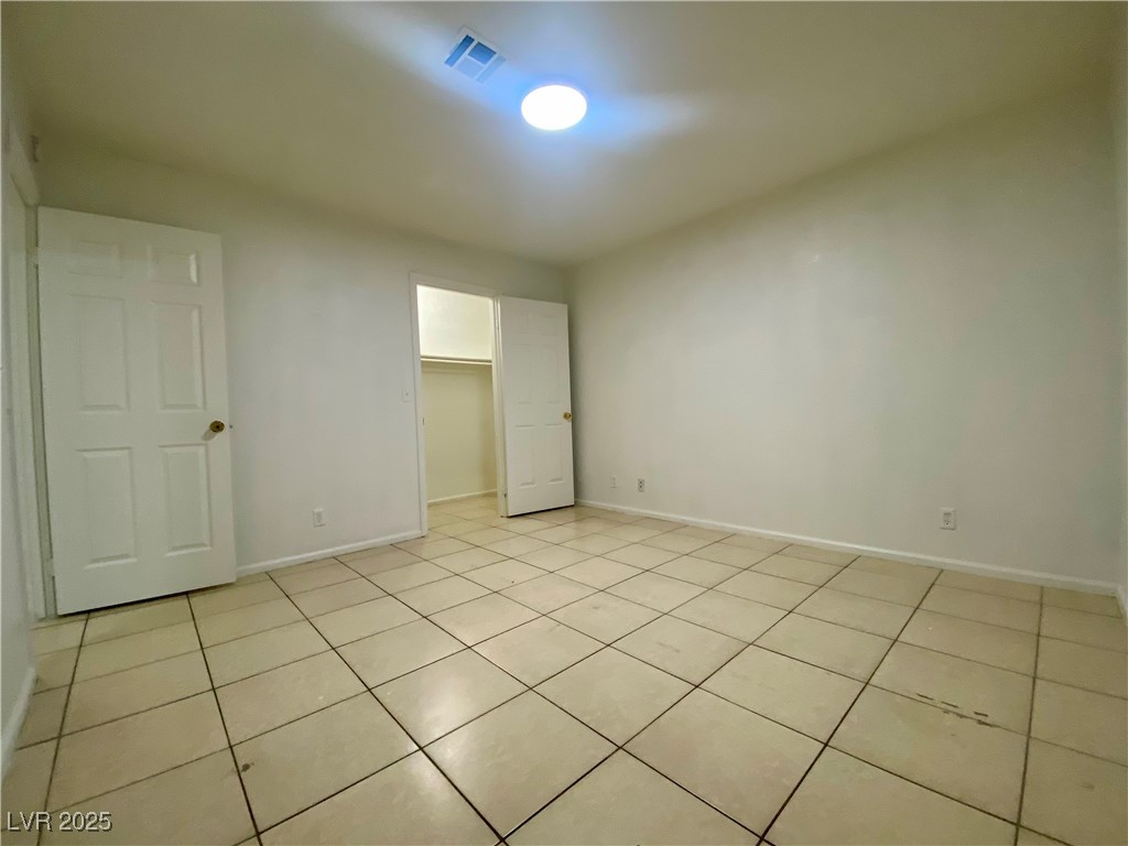 5284 Hagemann Lane, Unit D Las Vegas, NV 89110 - Photo 21 of 30 Unfurnished bedroom with light tile patterned flooring and a walk in closet