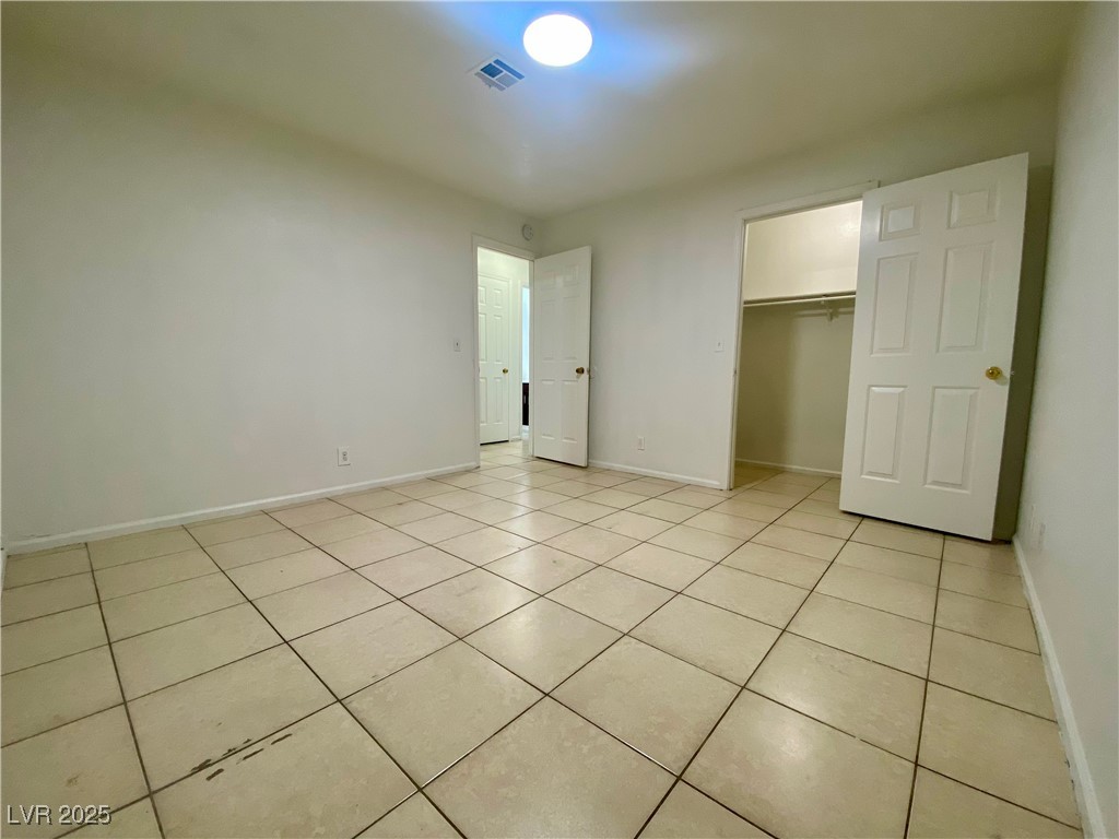 5284 Hagemann Lane, Unit D Las Vegas, NV 89110 - Photo 22 of 30 Unfurnished bedroom with light tile patterned flooring and a walk in closet