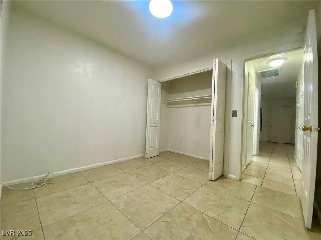 5284 Hagemann Lane, Unit D Las Vegas, NV 89110 - Photo 25 of 30 Unfurnished bedroom with light tile patterned floors and a closet