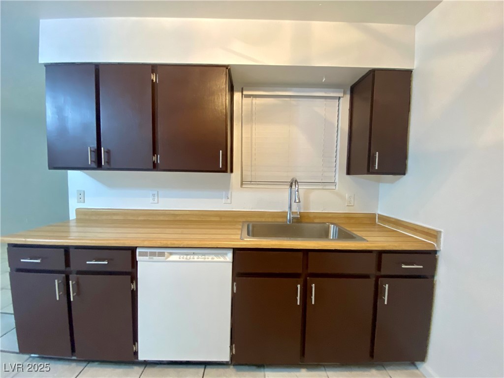 5284 Hagemann Lane, Unit D Las Vegas, NV 89110 - Photo 6 of 30 Kitchen featuring dishwasher, light countertops, dark brown cabinets, and light tile patterned floors