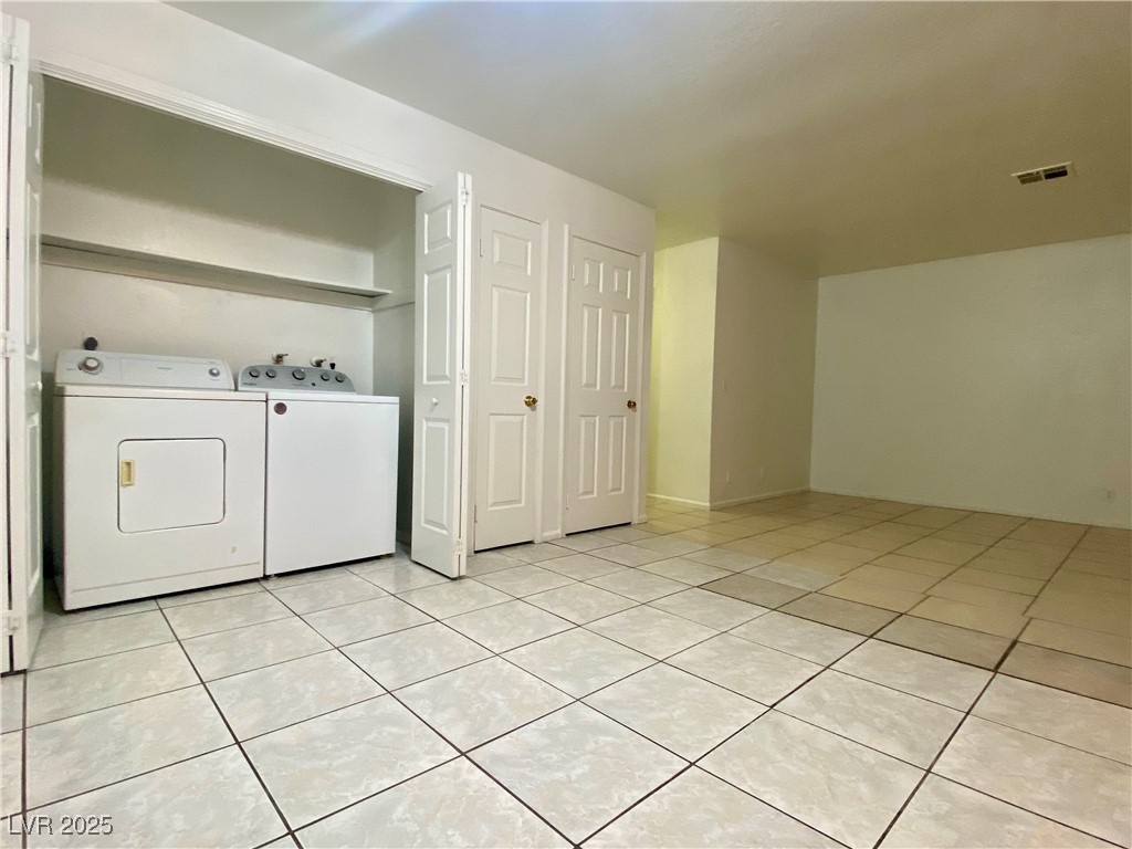 5284 Hagemann Lane, Unit D Las Vegas, NV 89110 - Photo 8 of 30 Laundry area with light tile patterned floors and separate washer and dryer