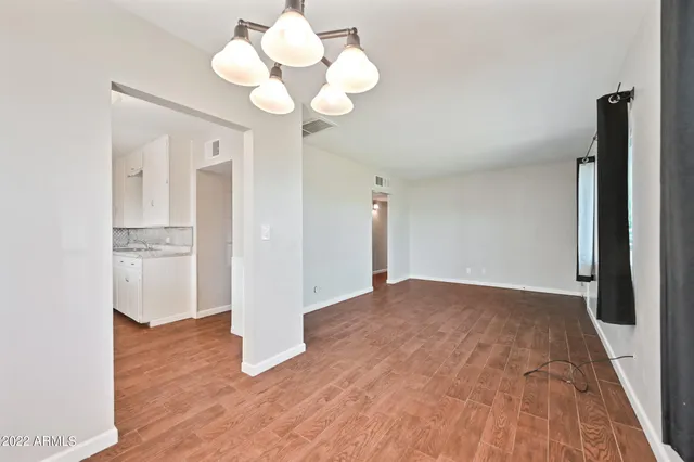 a view of empty room with wooden floor