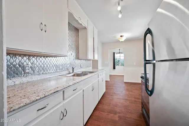 a view of a kitchen with a sink and refrigerator