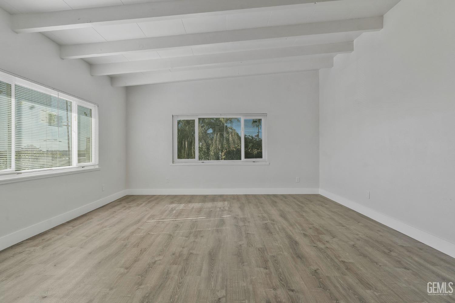 Undisclosed Address Bakersfield, CA 93305 - Photo 7 of 23 a view of an empty room with wooden floor and a window