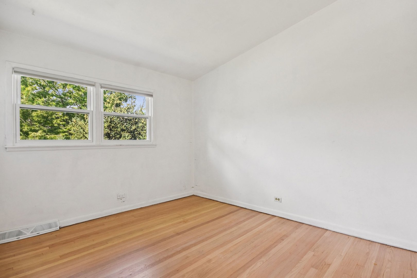 828 Lavergne Avenue Wilmette, IL 60091 - Photo 10 of 19 an empty room with wooden floor and windows