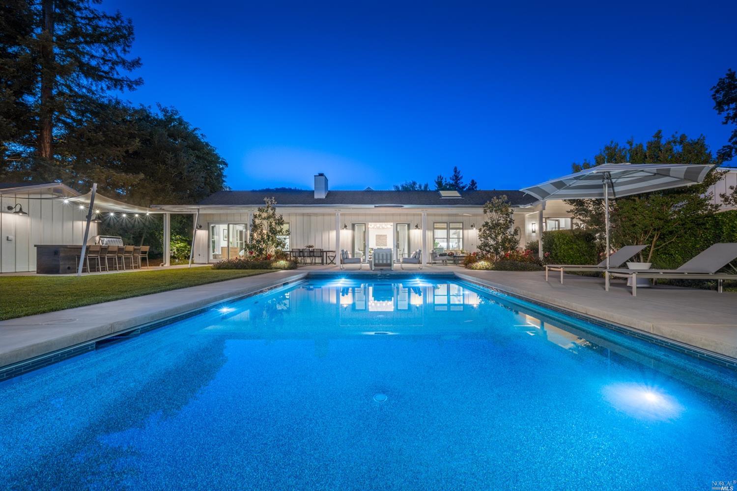 a view of a swimming pool with an outdoor seating and a yard