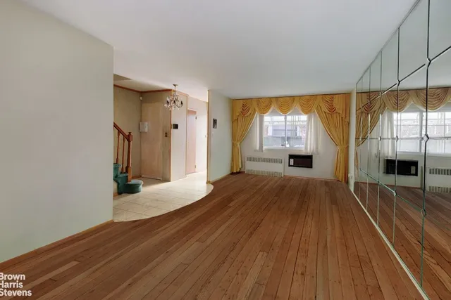 a view of a room with wooden floor and a window
