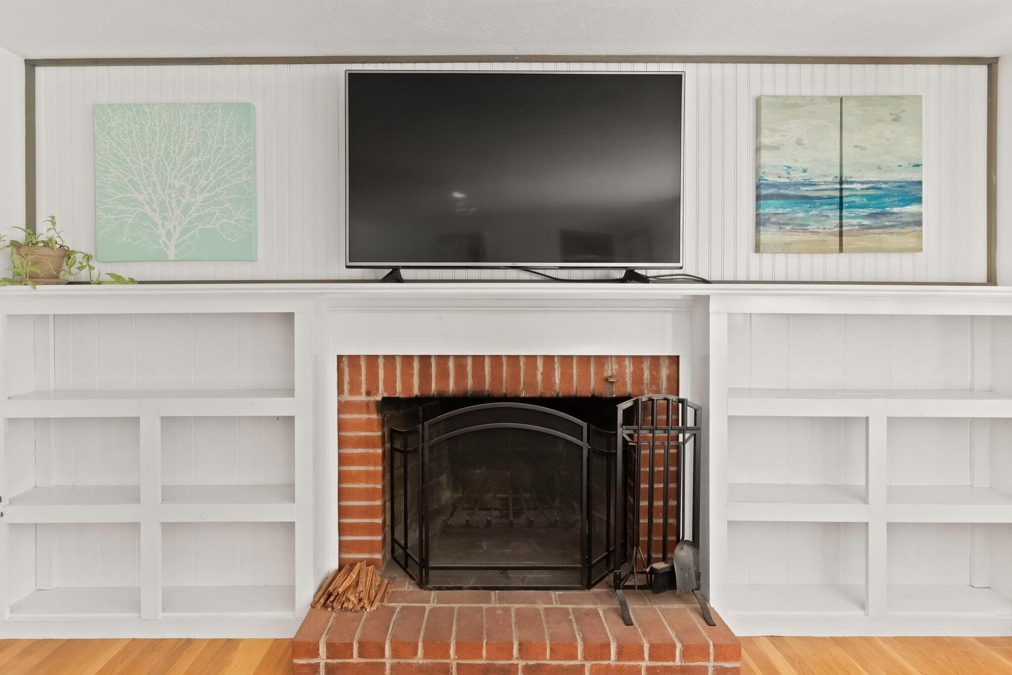 270 Mashpee Neck Road Mashpee, MA 02649 - Photo 14 of 36 a living room with a fireplace and a flat screen tv