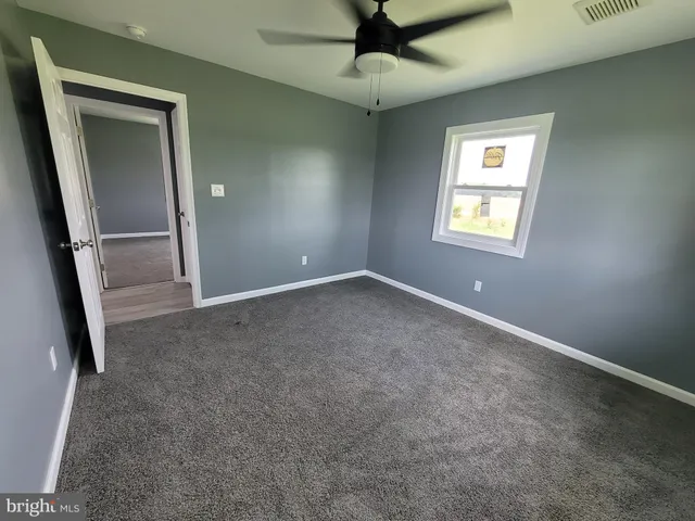 an empty room with a empty space and a ceiling fan