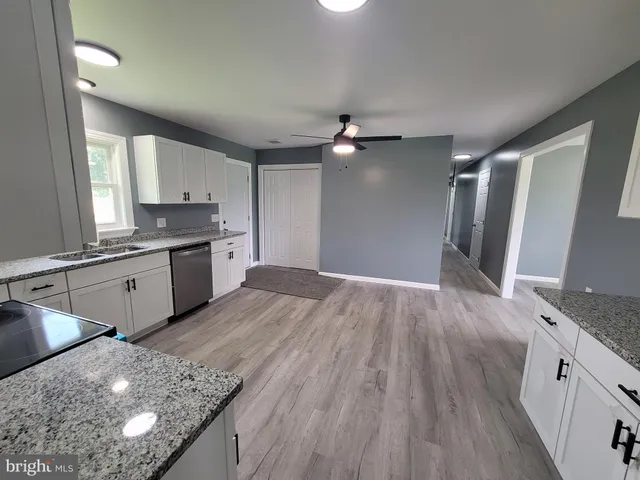 a kitchen with granite countertop a stove a sink and a refrigerator