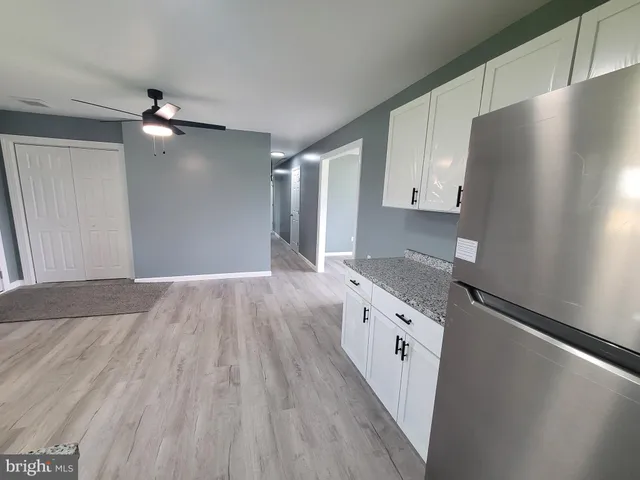 a kitchen with granite countertop a refrigerator a sink and dishwasher
