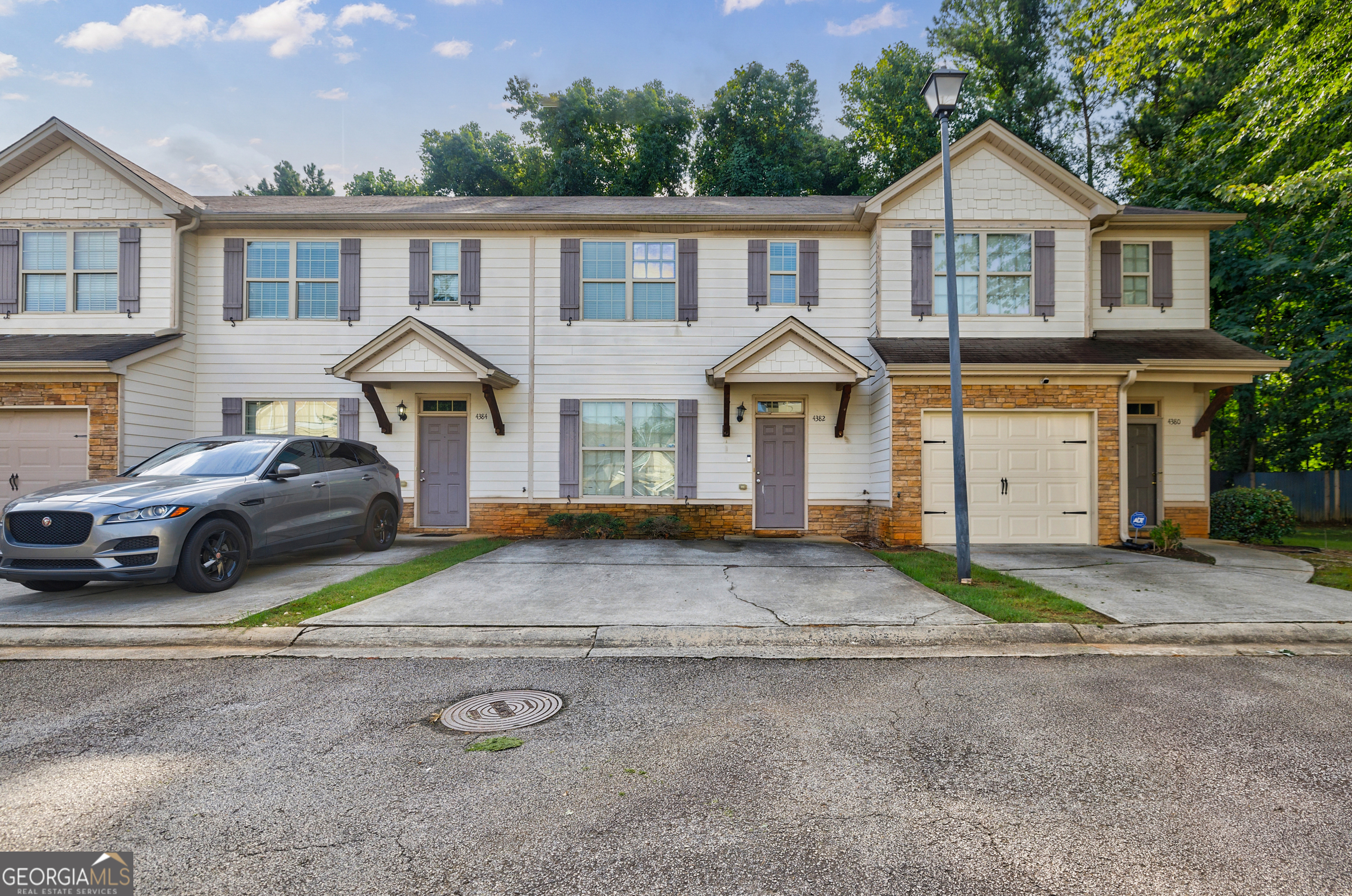 4382 Stone Gate Way, Unit 103 East Point, GA 30344 - Photo 1 of 1 a front view of a house with a yard and garage