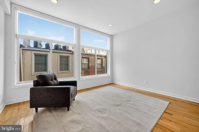 a view of staircase with lots of frames on wall and a potted plant