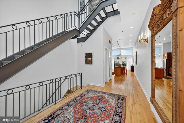 a view of a hallway with furniture and wooden floor