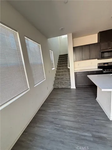 a kitchen with wooden floor and electronic appliances