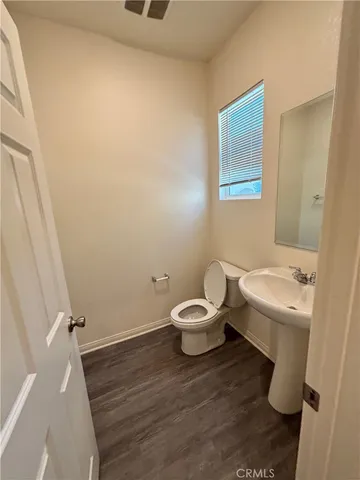 a white toilet sitting next to a white sink and vanity