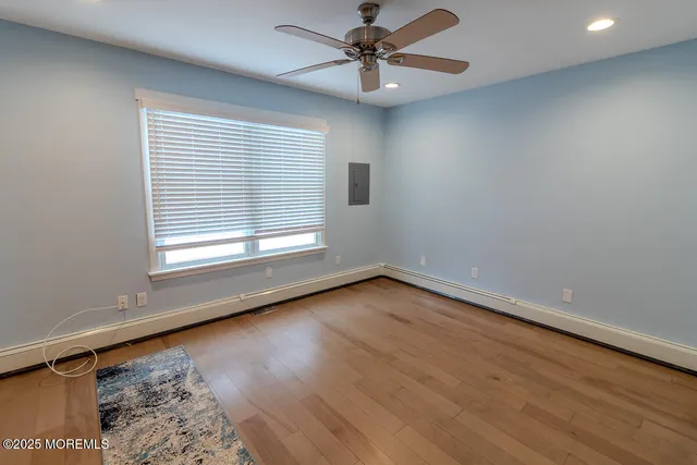 an empty room with a window and ceiling fan