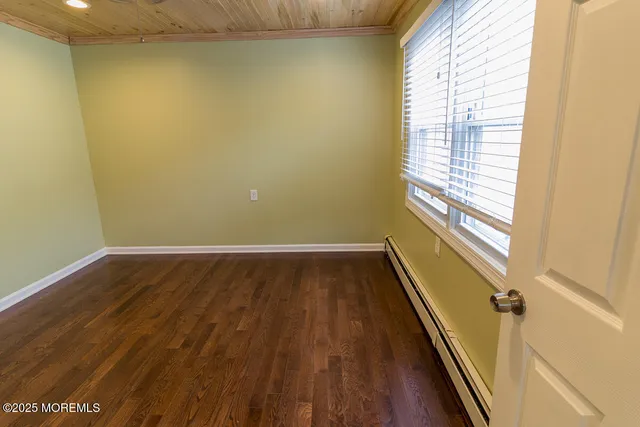 a view of a room with wooden floor and a window