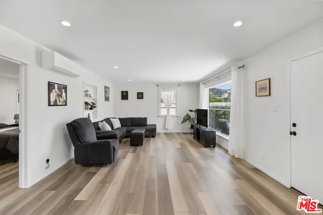 a living room with furniture and a wooden floor