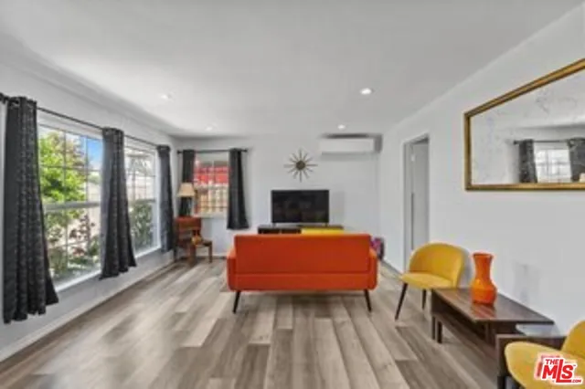 a living room with furniture a flat screen tv and a large window