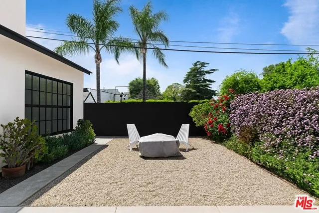 a view of a chair and table in backyard of the house