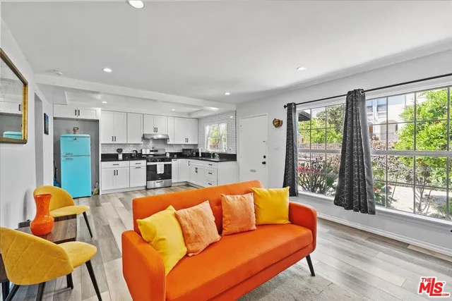 a living room with furniture wooden floor and a large window