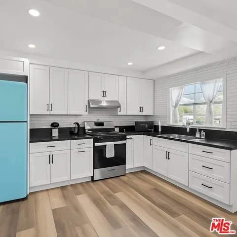 a kitchen with granite countertop white cabinets and white appliances