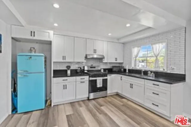a kitchen with granite countertop a sink stove and refrigerator