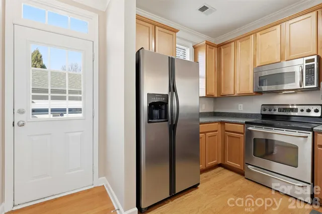 a kitchen with stainless steel appliances granite countertop a refrigerator and a stove top oven