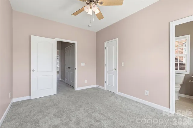 a view of an empty room and chandelier fan