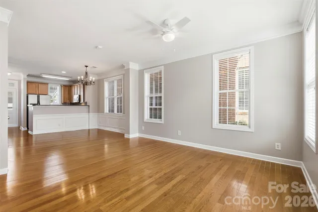 a view of an empty room with window and wooden floor