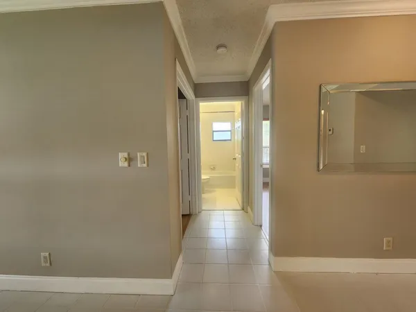 an empty room with windows and chandelier fan
