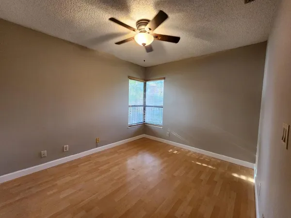 a view of room with hardwood floor and ceiling fan