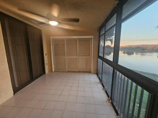 a view of empty room with balcony and wooden floor
