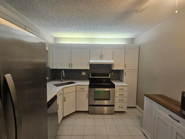 a kitchen with a refrigerator sink and cabinets