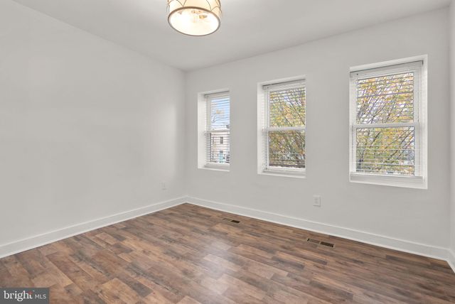 a view of a room with wooden floor and sliding glass door