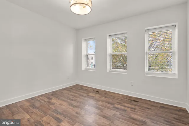 a view of a room with wooden floor and sliding glass door
